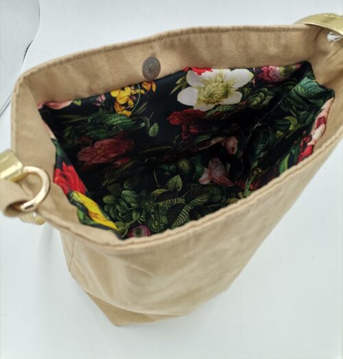 Wnętrze beżowej torebki z nubuku - podszewka w kwiaty i liście na ciemnym tle
