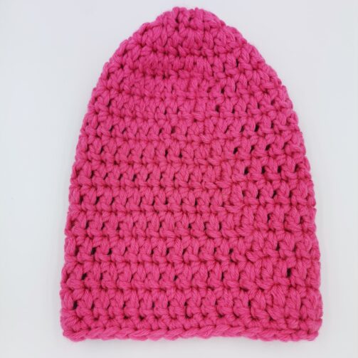 Różowa czapka o wyraźnym splocie, wykonana ręcznie z włóczki