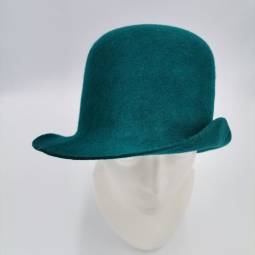 Zielony kapelusz prezentowany na głowie manekina.