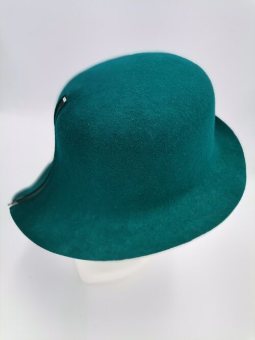 Zielony kapelusz prezentowany na głowie manekina.