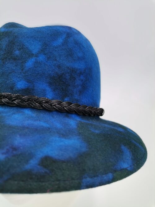 Detal kapelusza w odcieniach niebieskiego i zieleni.