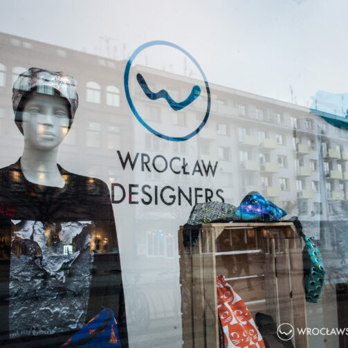 Witryna sklepu odzieżowego we Wrocławiu Wrocławscy Projektanci, z manekinem ubranym w bluzę i czapkę. Obok wyeksponowane nerki